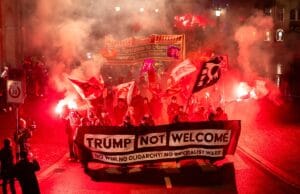 U.S. Flags Torched And Fires Set As Demonstrators Confront Trump Ahead Of Davos Summit